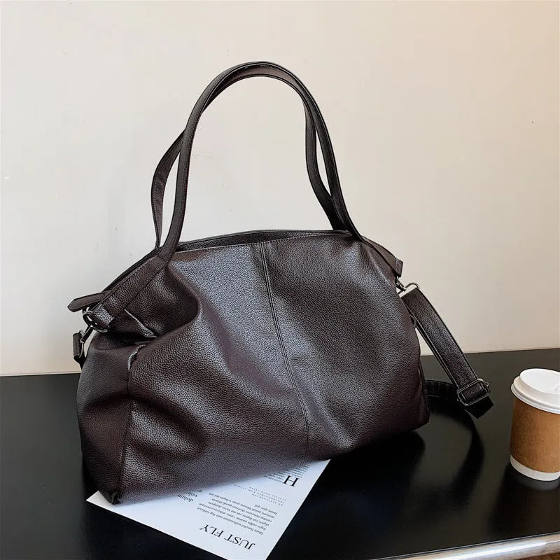 Soft surface PU leather messenger tote bag in a horizontal square shape with an adjustable shoulder strap.