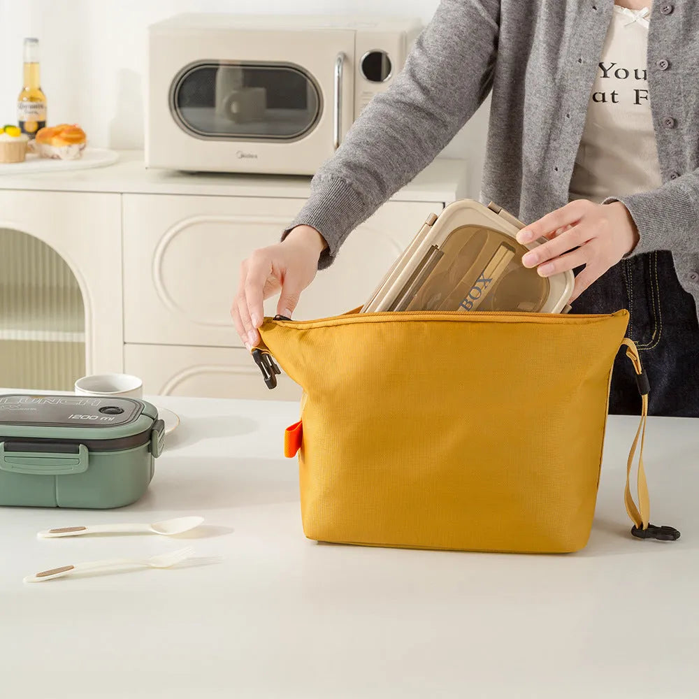 Japanese-style insulated lunch bag in Oxford cloth, shown open with a lunch box inside.