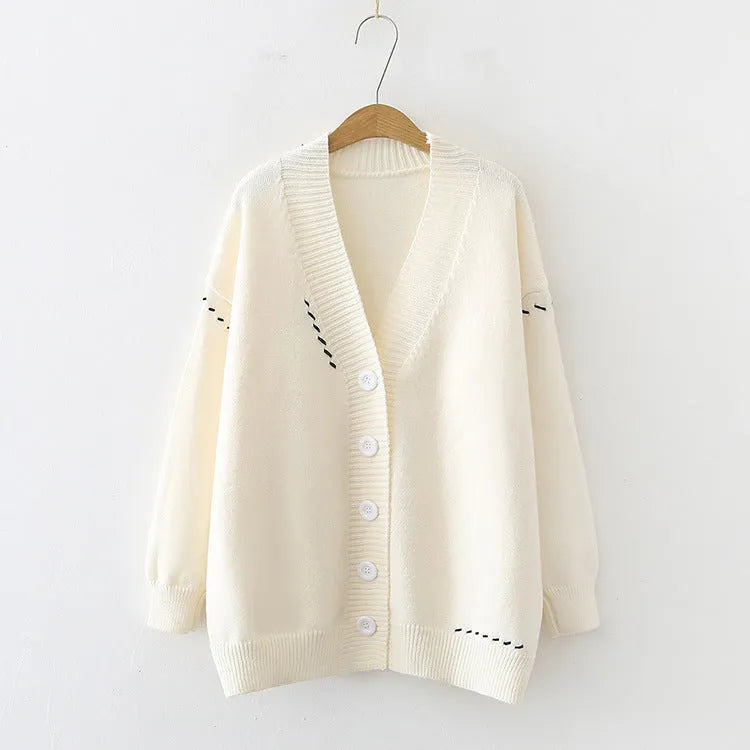 A women's loose-fit knitted cardigan coat in black, showing long sleeves and a solid colour design.