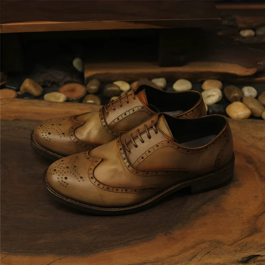 Men's light brown distressed leather lace-up shoes with engraved carving details on the upper.