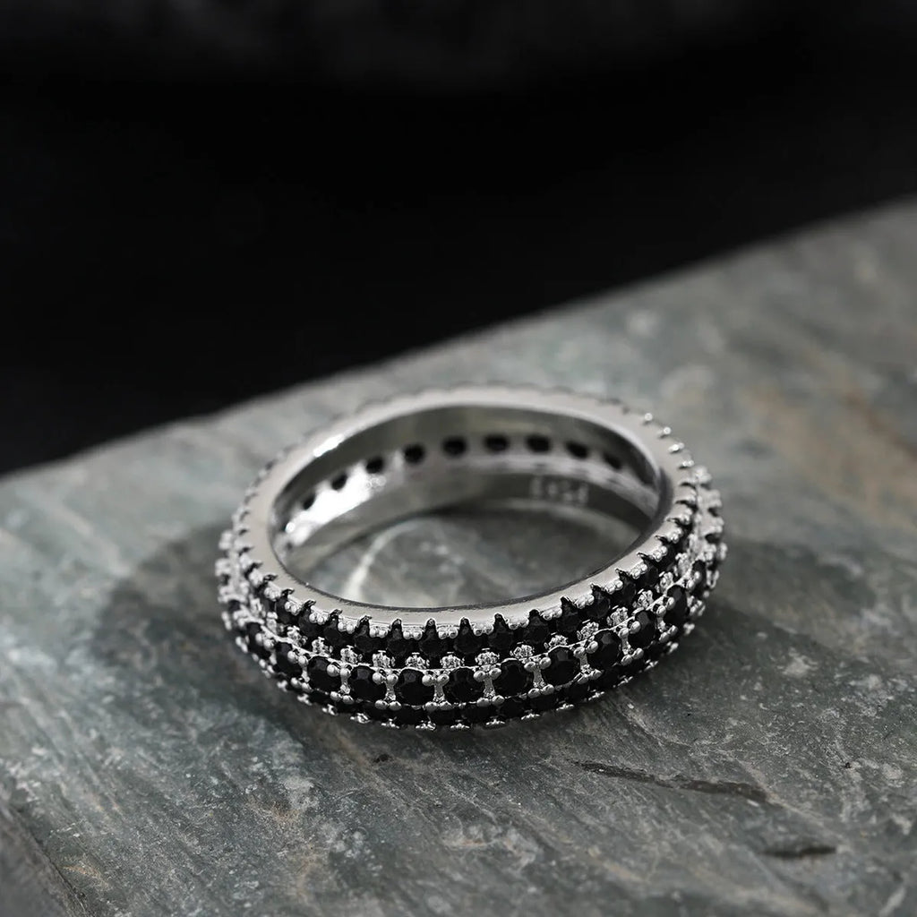 Geometric copper ring with a triangular zircon stone inlay, shown on a finger.