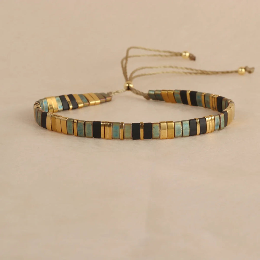 Geometric round glass bead bracelet in five colour options on a wrist.