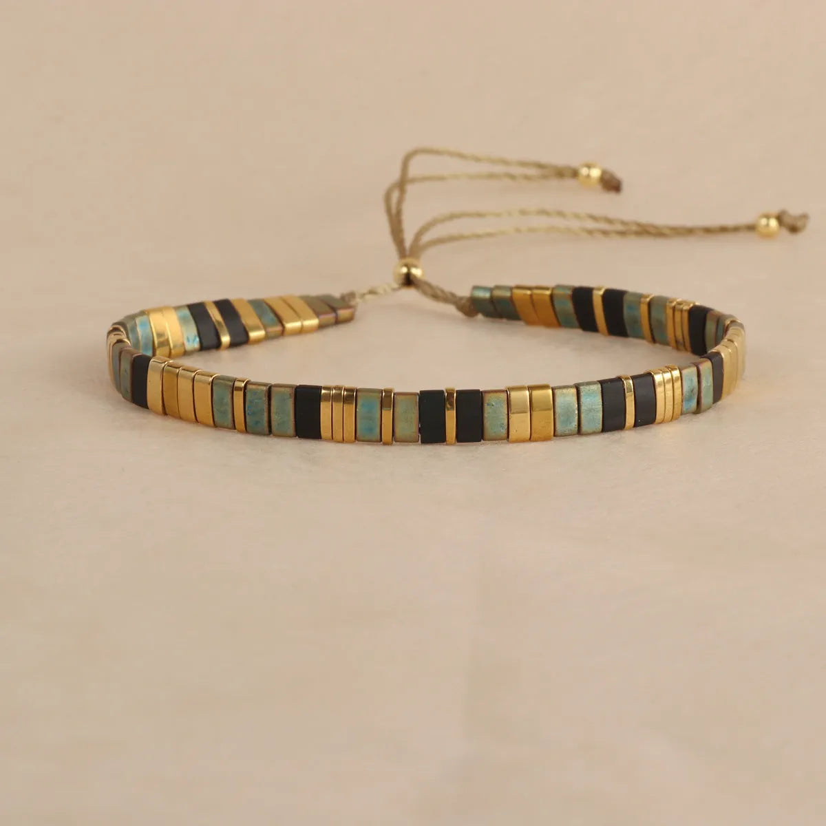 Geometric round glass bead bracelet in five colour options on a wrist.