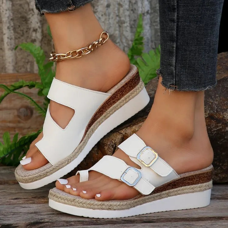 White women's wedge sandals with a woven patent leather upper and peep toe design.