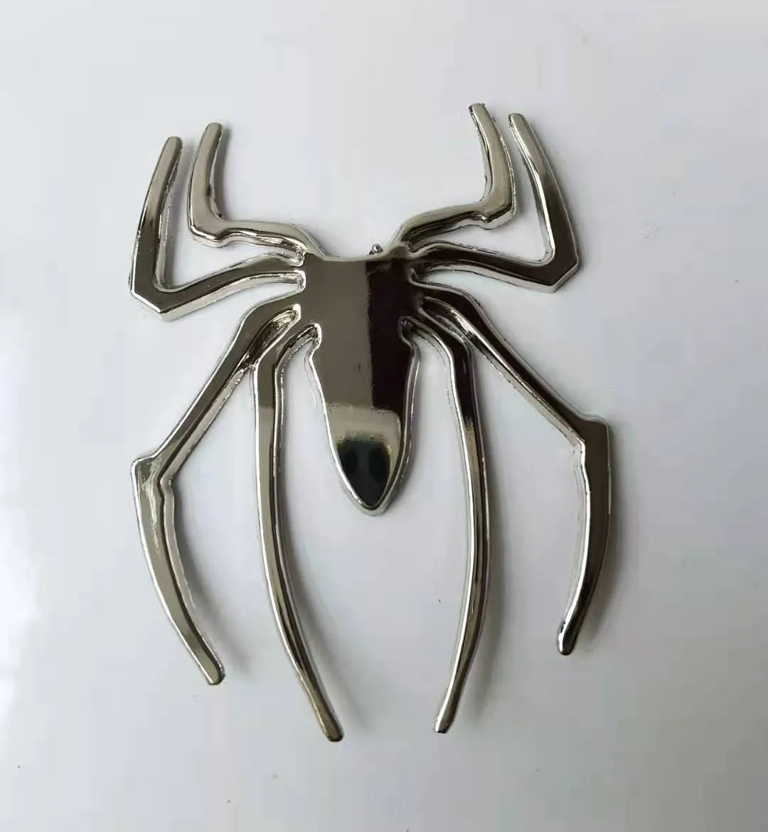 Three-dimensional metal spider bumper sticker in metallic finish measuring 7cm by 5cm