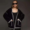 Loose mid-length knitted cardigan in camel colour on a hanger