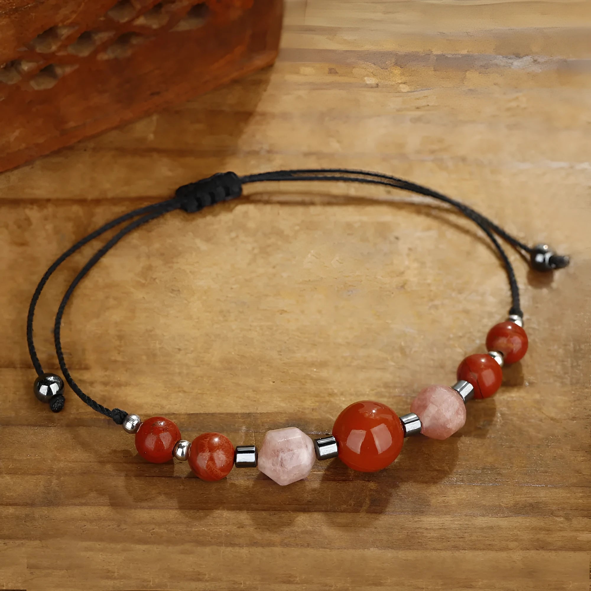 Handmade red crystal bracelet with sunstone, redstone and copper beads in a geometric design.