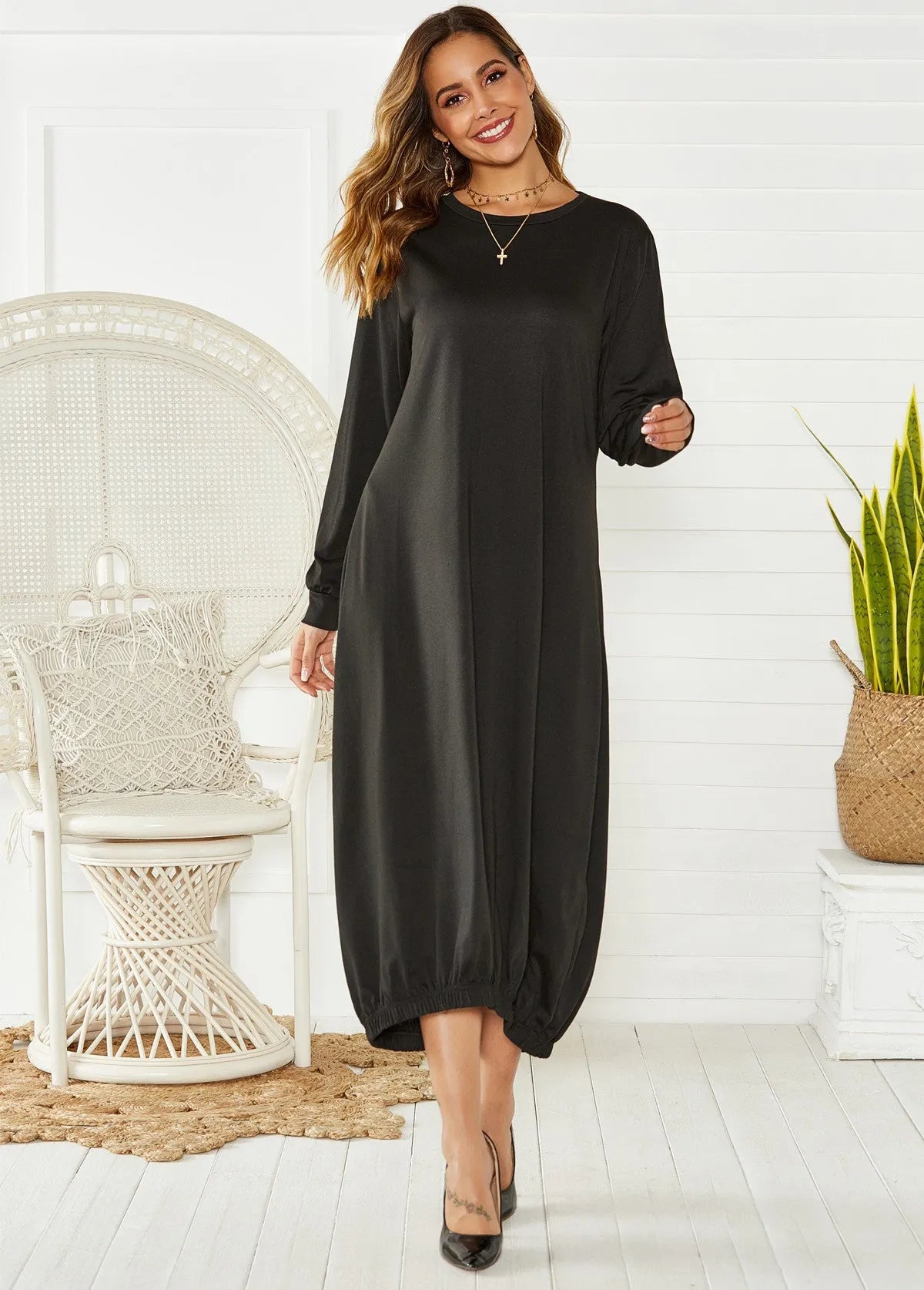 Loose black lantern dress with lace-up crew neck and threads detailing on a mannequin