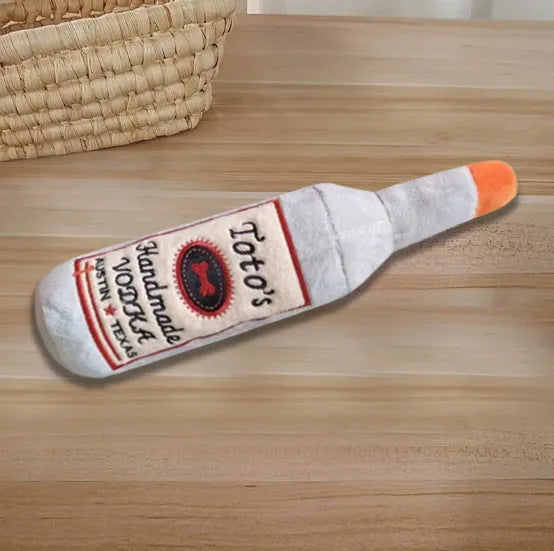 Brown plush dog toy shaped like a wine bottle with a textured surface.