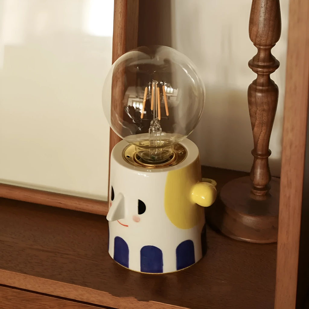Handmade white ceramic table lamp with a creative ball headlight design on a wooden surface.