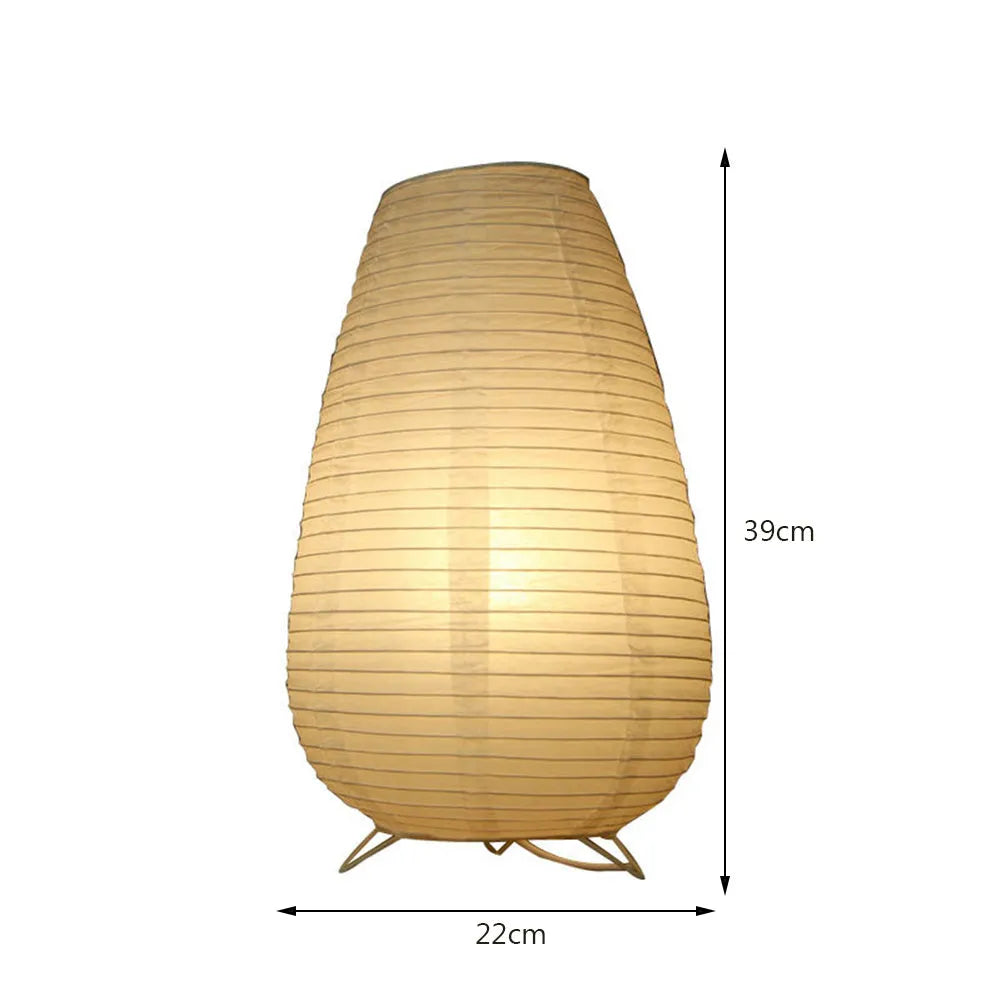 White handcrafted rice paper table lamp with either a circular or rectangular shade on a wooden desk.