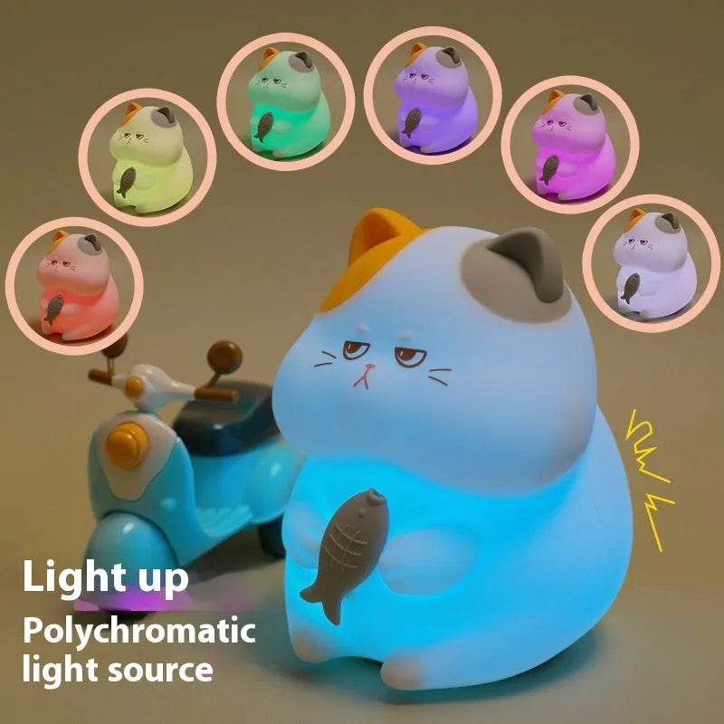 Small greedy cat cartoon desktop night light with yellow fin tuna design on a desk.