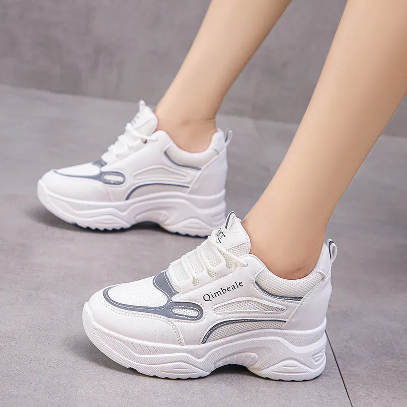 White height increasing dad shoes with mesh upper and wedge heel on a neutral background