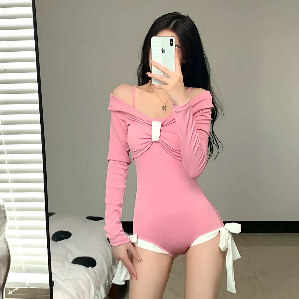 Women's long sleeve one-piece swimsuit in black or pink, made from polyester fabric.