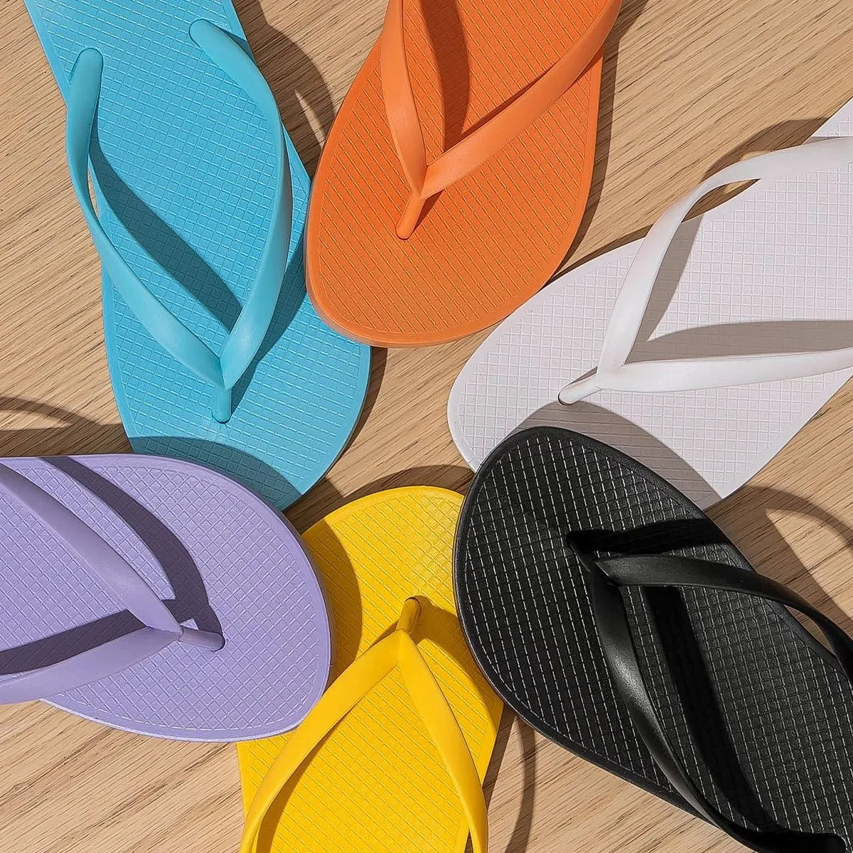 Orange foldable flat slippers with a non-slip PVC sole and breathable hollow-out plastic upper.