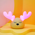 Children bedside Christmas deer night light with colour-changing LED and soft silicone shade on a table