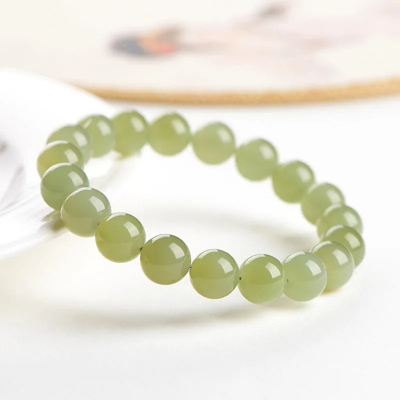 Polished Hetian jade bead bracelet in ice-like clear colours on a white background.