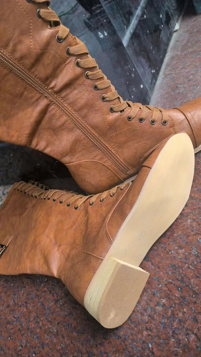 Women's black cross strap knight boots made from artificial PU, showing the strap detail and ankle height