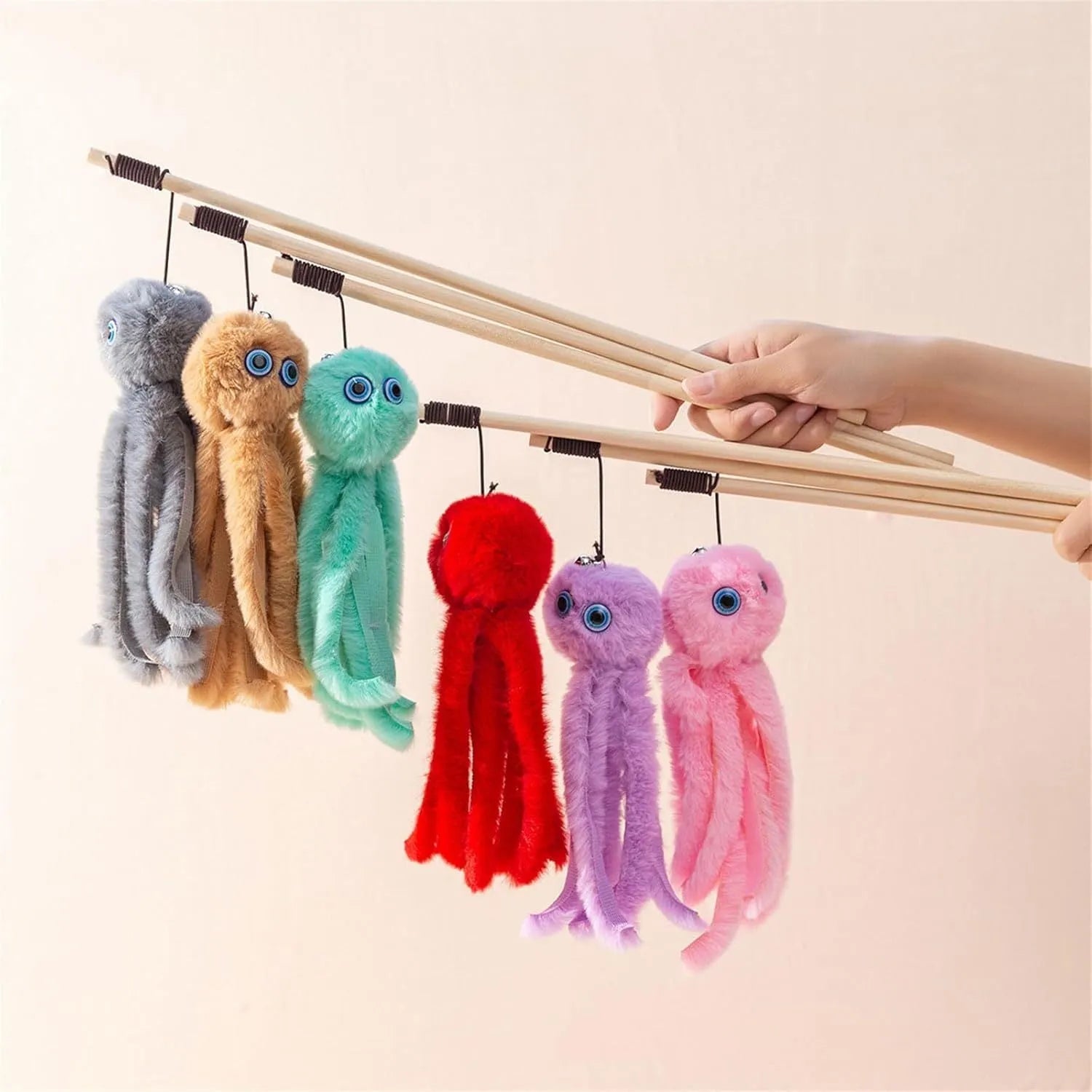 Octopus design cat toy with movable eyes on a long stick, shown in grey, pink, purple, or red.