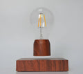 Magnetic levitation desk lamp with floating light bulb on imitation wood base.