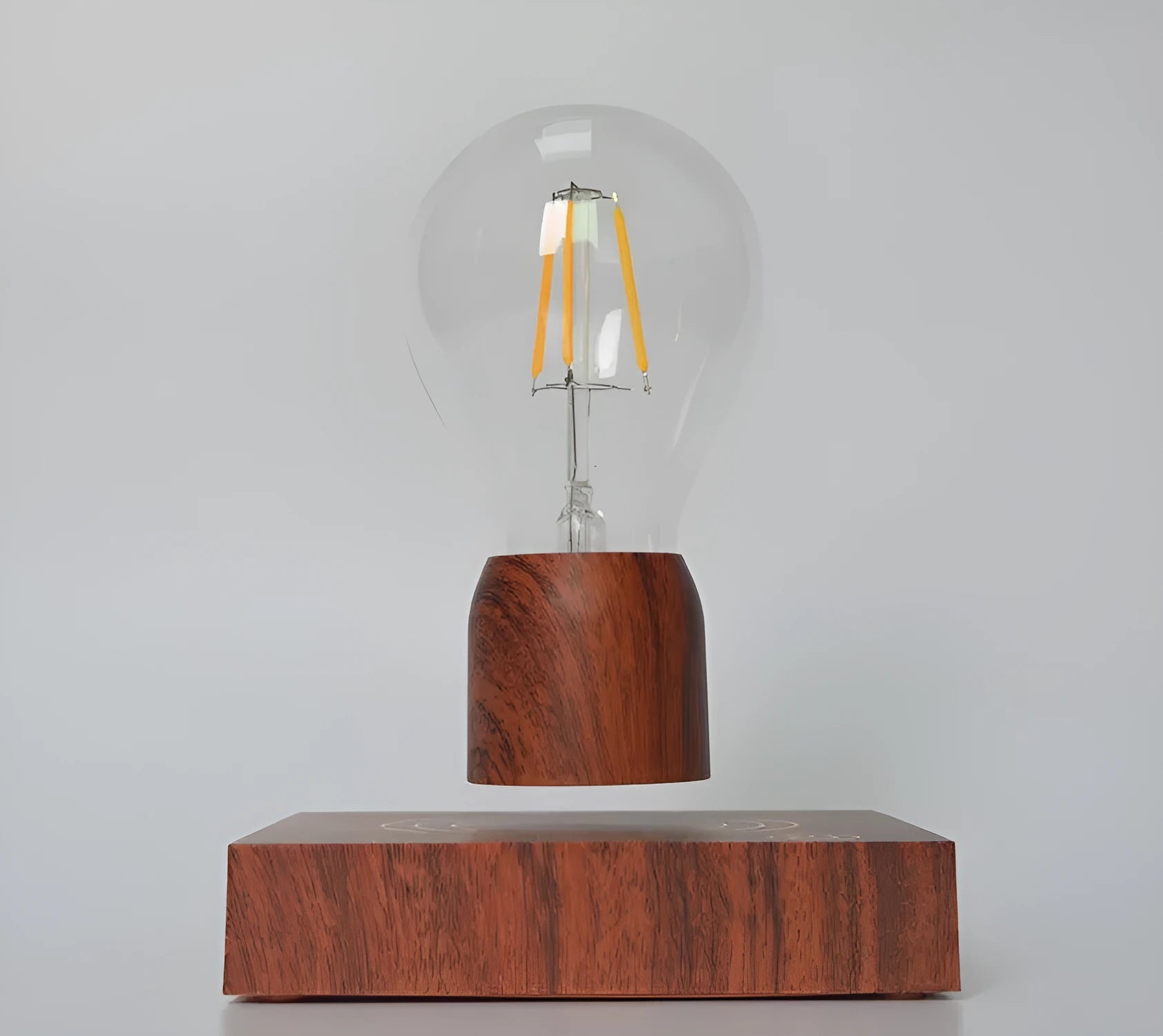 Magnetic levitation desk lamp with floating light bulb on imitation wood base.