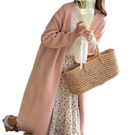 A woman's loose-fit knitted cardigan in a khaki colour with a V-neck and long sleeves, laid flat.