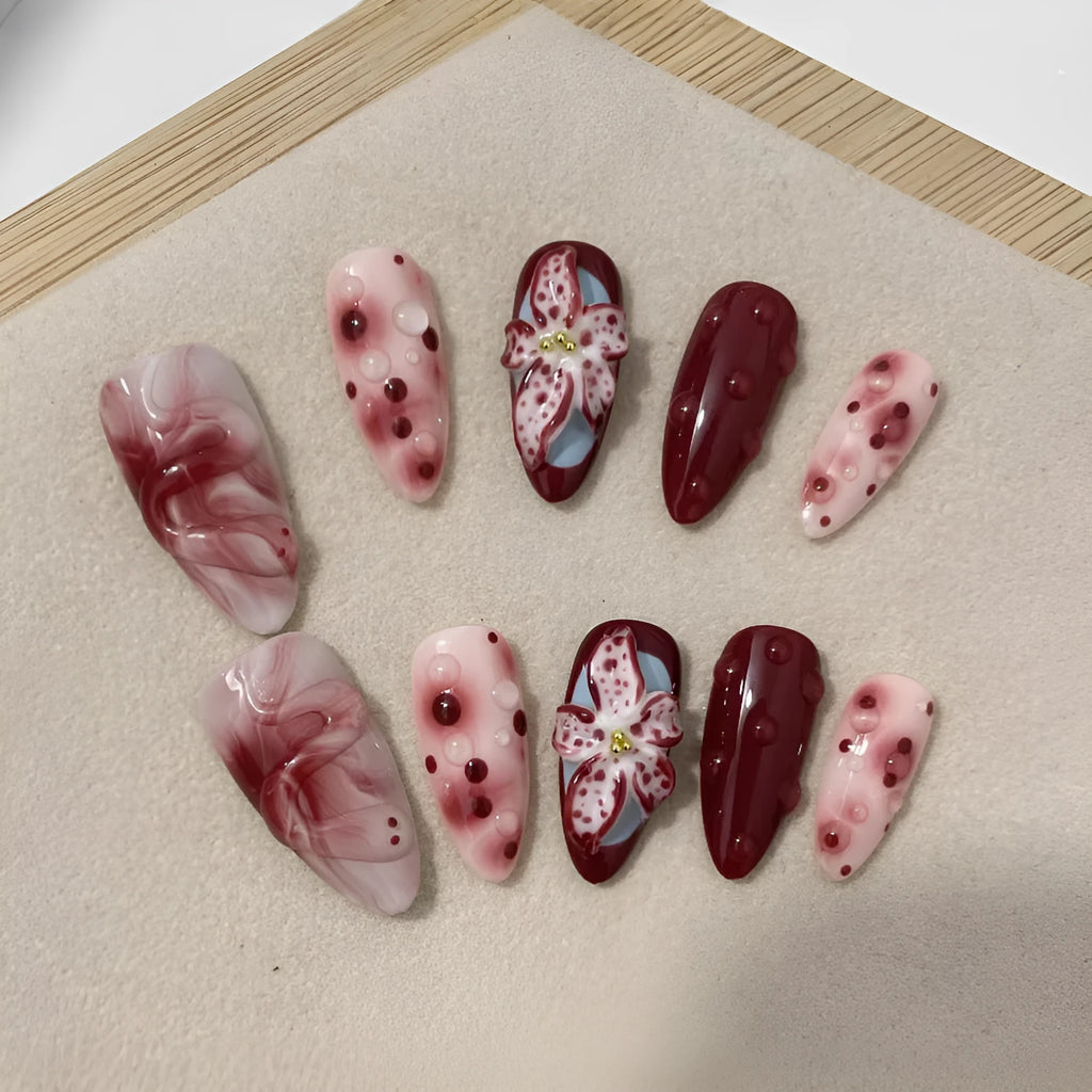 Hand-painted 3D floral artificial press-on nails in almond colour with cat's eye finish.