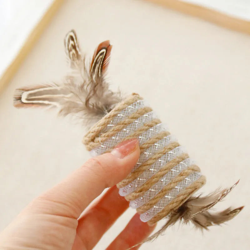 Beige cat toy with feathers, hemp rope scratching area and a central sound roller for pet claw play.
