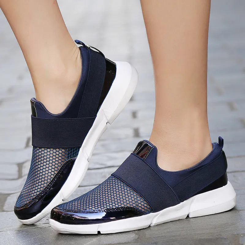 Blue, black, and grey women's low-cut mesh sneakers with a PU midsole on a hard floor.