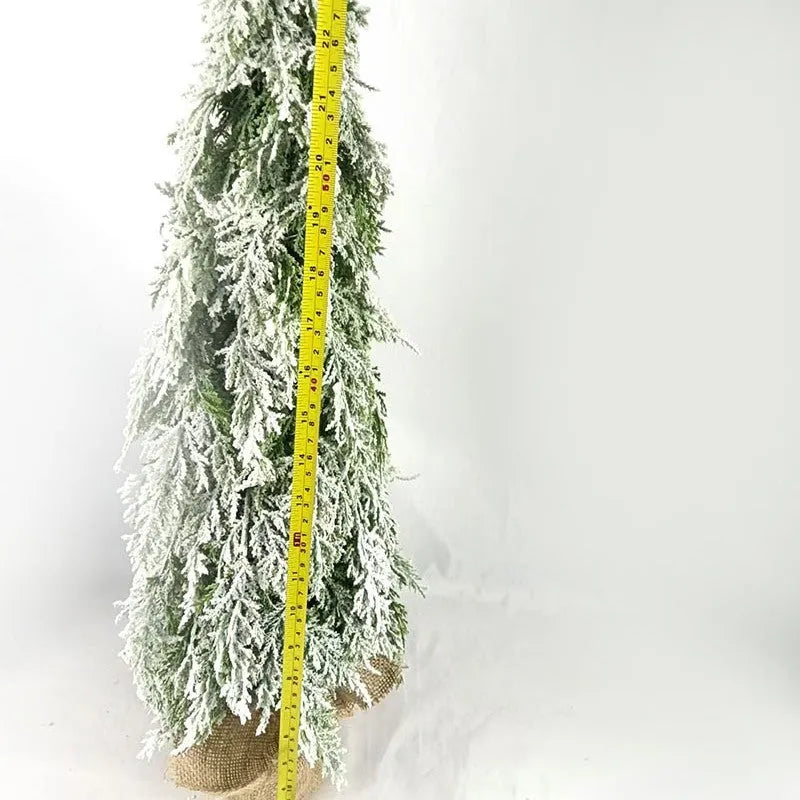 Small 24-inch frosted artificial Christmas tree with LED lights on a desktop.