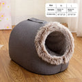 Grey fleece-lined closed cat sleeping bag with portable handle on brown floor