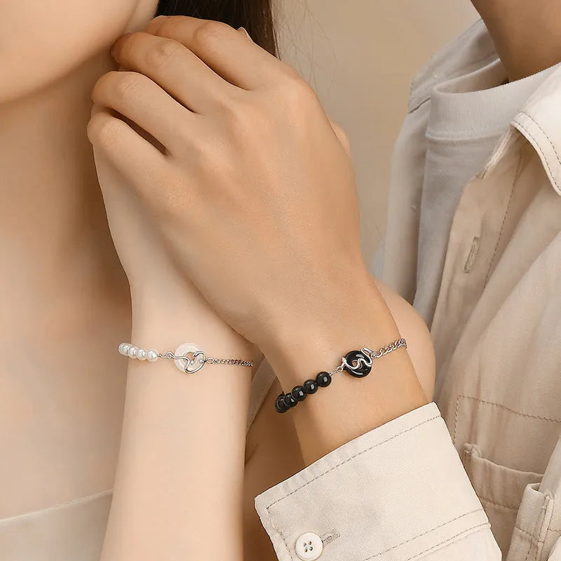 A New Chinese style 925 sterling silver couple's bracelet with a safe buckle, snake motif, and a central obsidian pearl.