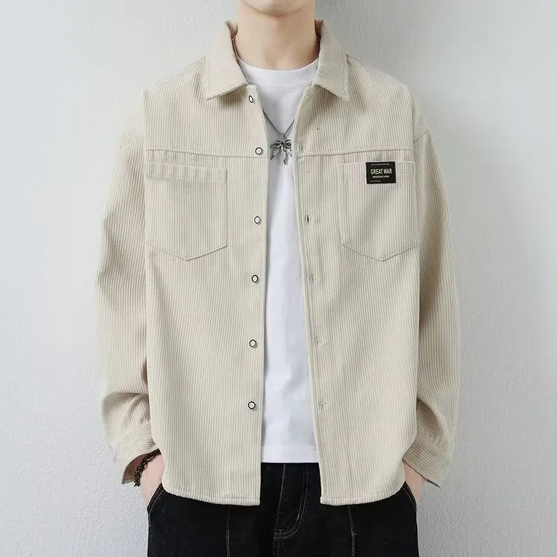 Man wearing a dark grey corduroy cardigan-style jacket with long sleeves.