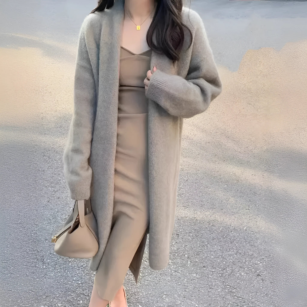 A woman's loose-fit knitted cardigan in a khaki colour with a V-neck and long sleeves, laid flat.
