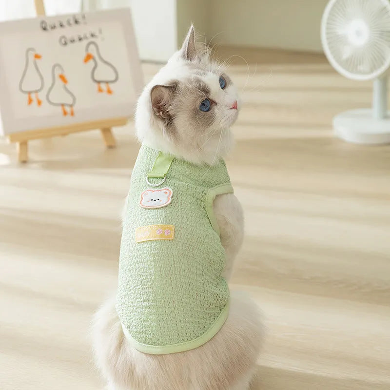 Cat wearing green bear patch cartoon clothing with hollowed-out breathable design
