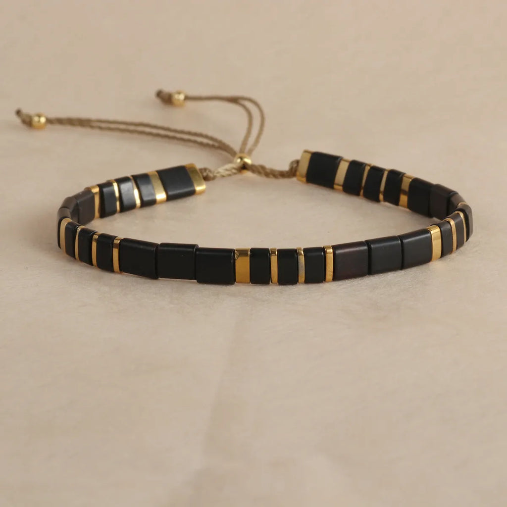 Geometric round glass bead bracelet in five colour options on a wrist.