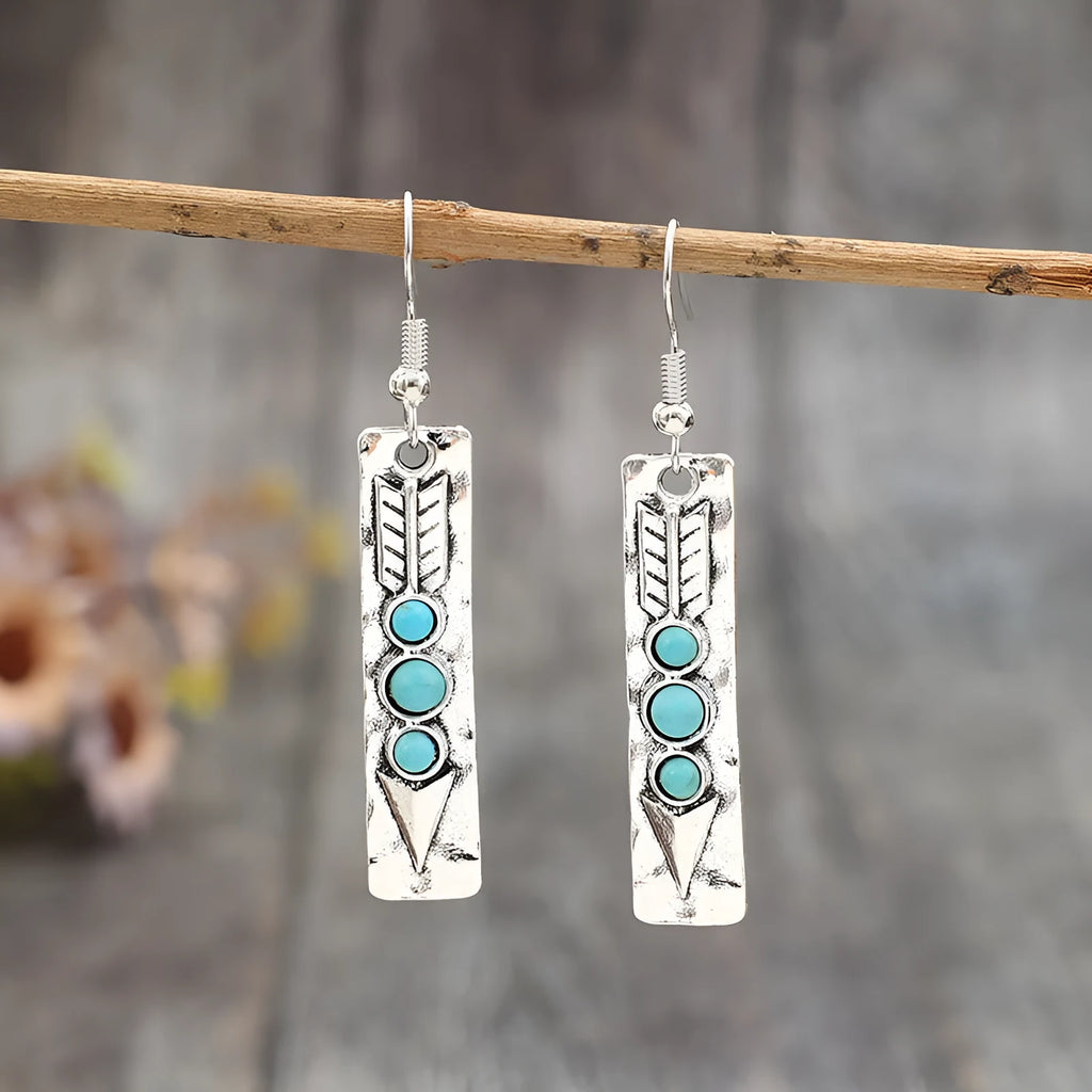 Silver geometric earrings with turquoise detail on white background