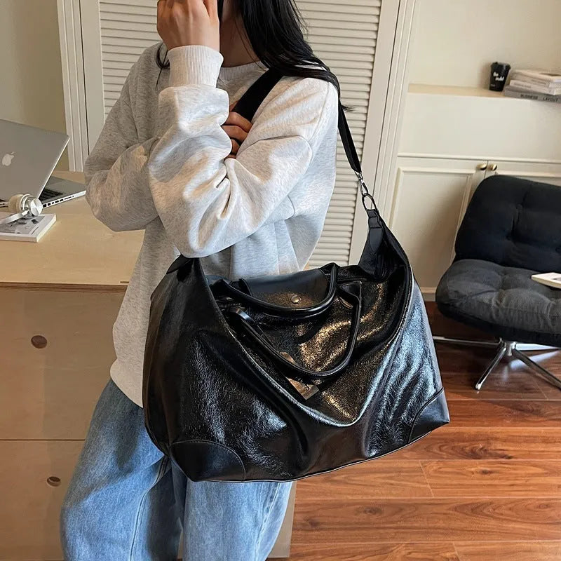 Women's black hand-carry travel bag with 36-55L capacity and polyester lining