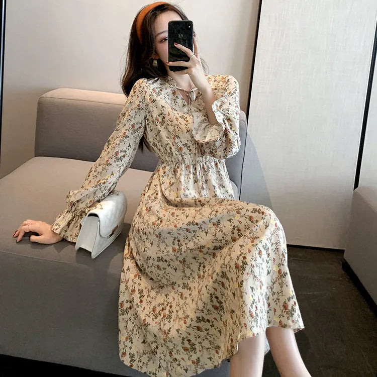 Retro waist-cinching floral A-line dress in apricot colour with princess-style seams, shown on a woman