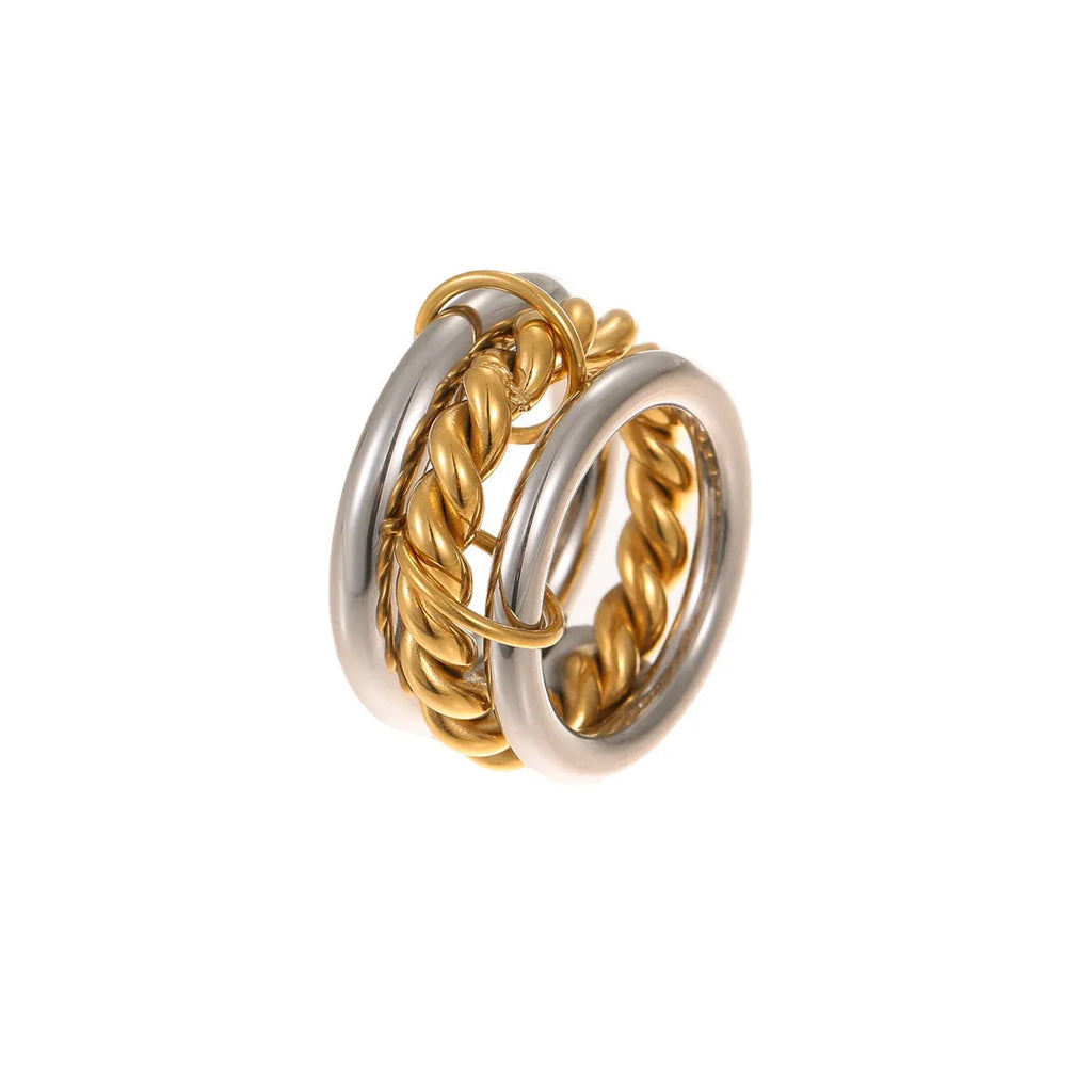 Stacked colour matching stainless steel ring with gold plating and exaggerated design on a woman's hand.