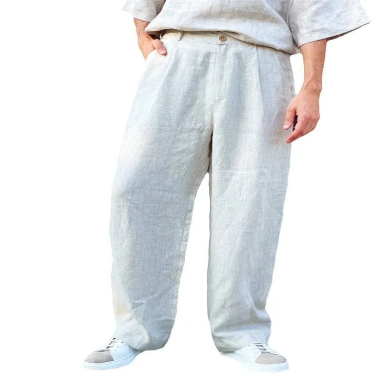Man wearing loose grey linen high-waist jogger pants with a zip fly, casual style