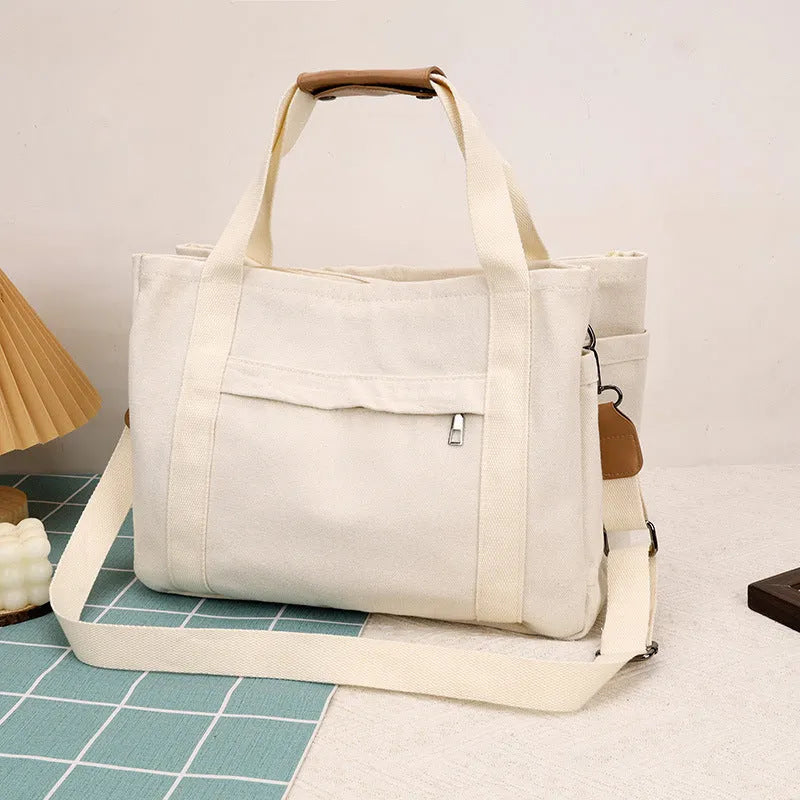 Canvas tote bag with multiple internal pockets including computer pocket, shown in horizontal square shape