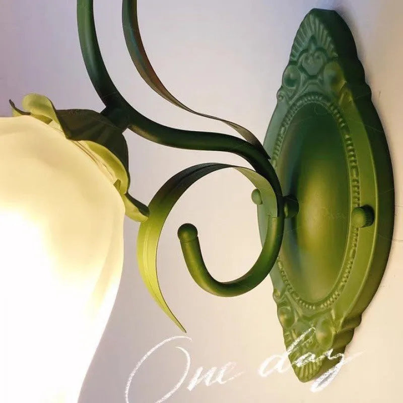Green pastoral style flower-shaped wall lamp with a glass shade and integrated LED light.