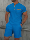 Man wearing a grey waffle-textured zip polo short sleeve top and matching shorts from a two-piece suit set.