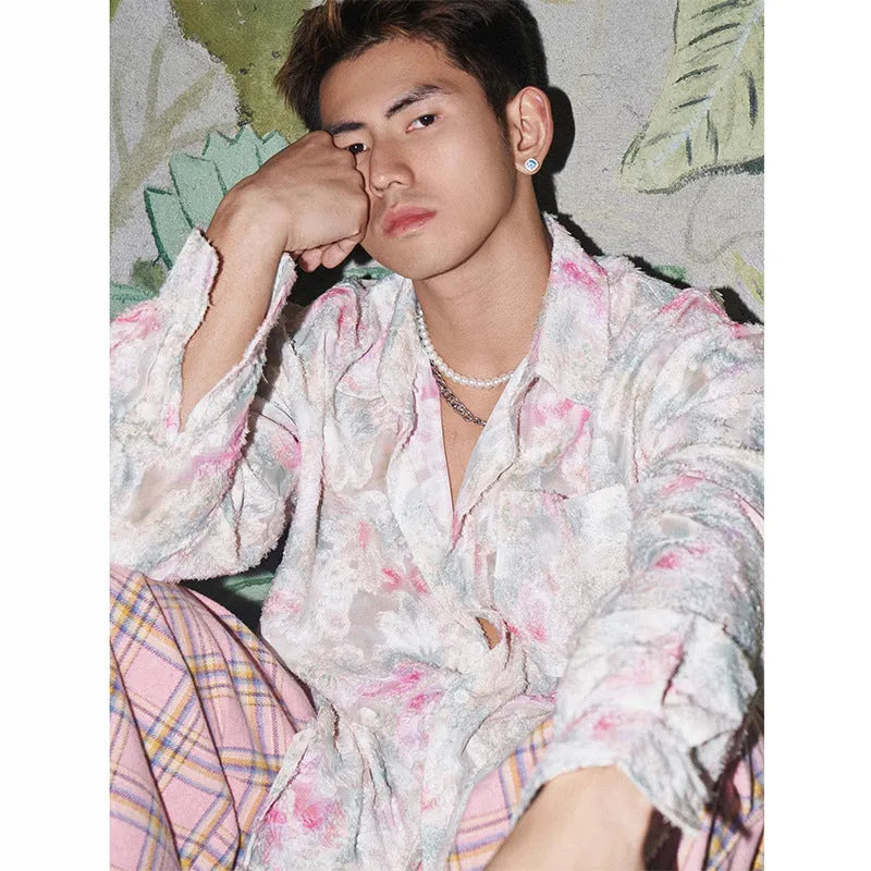Pink embossed floral pattern long sleeve shirt laid flat, showing loose fit and textured design.