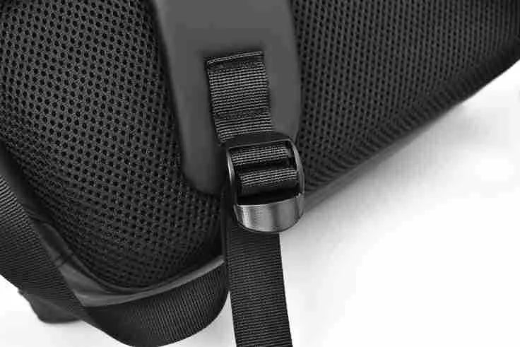 Men's large waterproof black PU leather backpack with laptop compartment on a grey background.