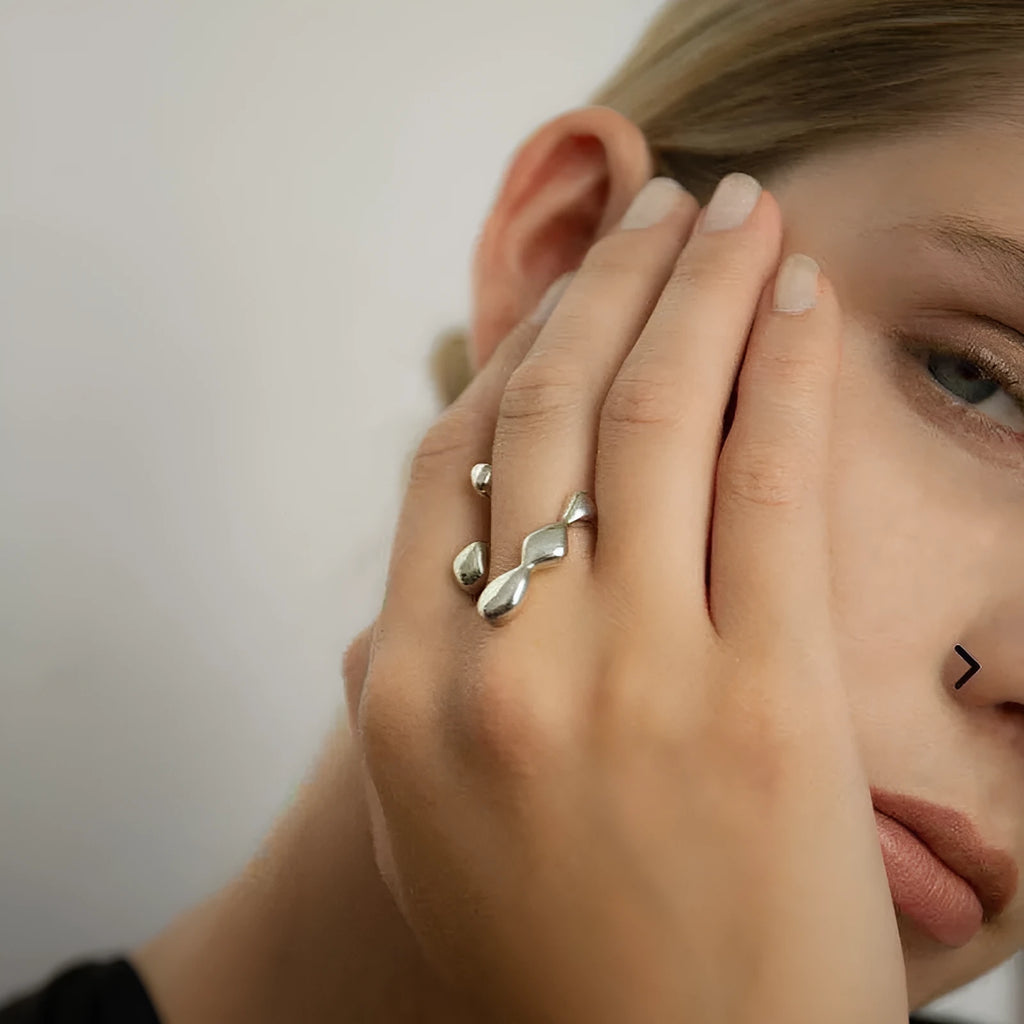 Adjustable brass ring with sphere design in gold or silver plating.