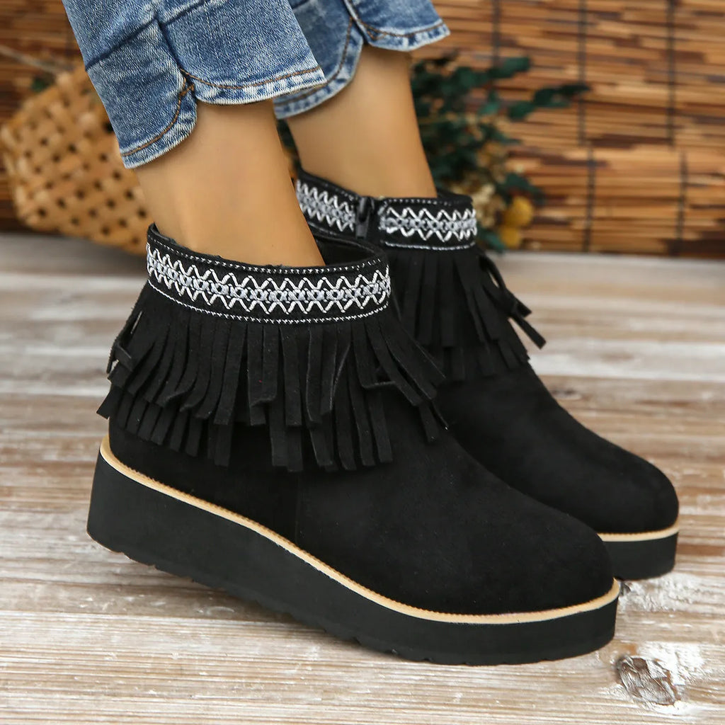 Women's black suede wedge ankle boots with side zipper, tassel detail, and thick rubber sole.