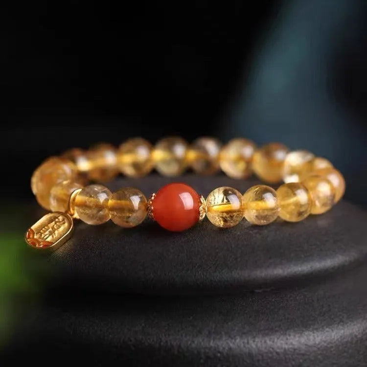 Polished natural red agate lucky beads bracelet on a wrist, showing ruby colour beads.