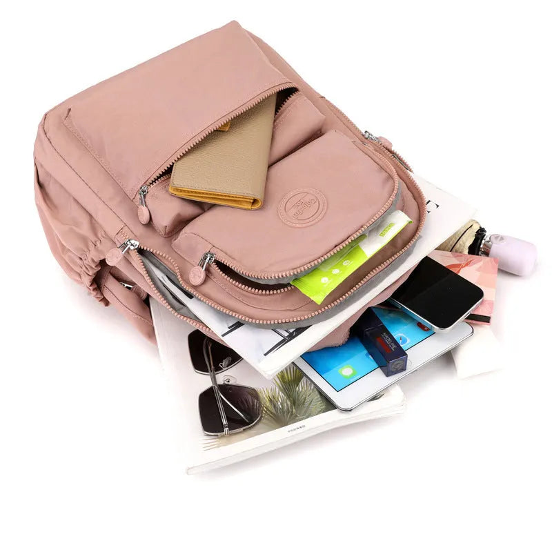 Women's nylon travel backpack in Azure Stone Green showing multiple compartments and organisational features